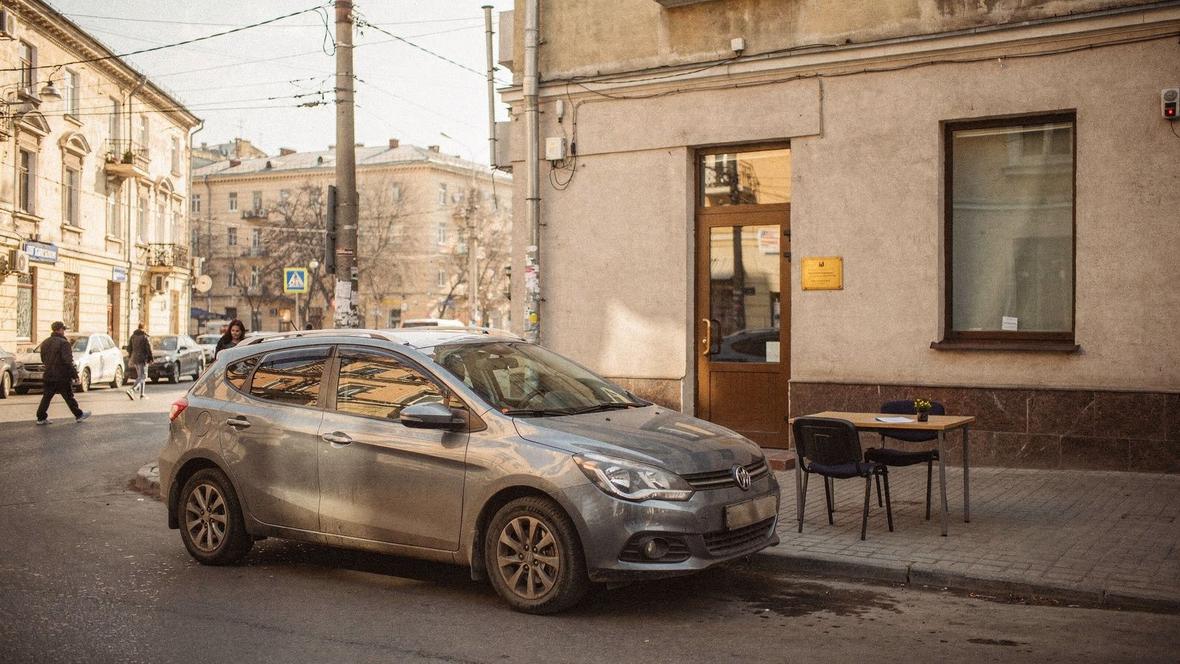 Handover counter on Khreshchatyk Street in Kyiv with a compact hatchback waiting at the kerb